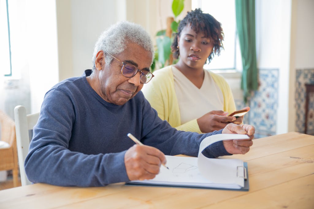 Branding 2 A Man in Blue Sweater Holding a Pen and Writing on a White Paper